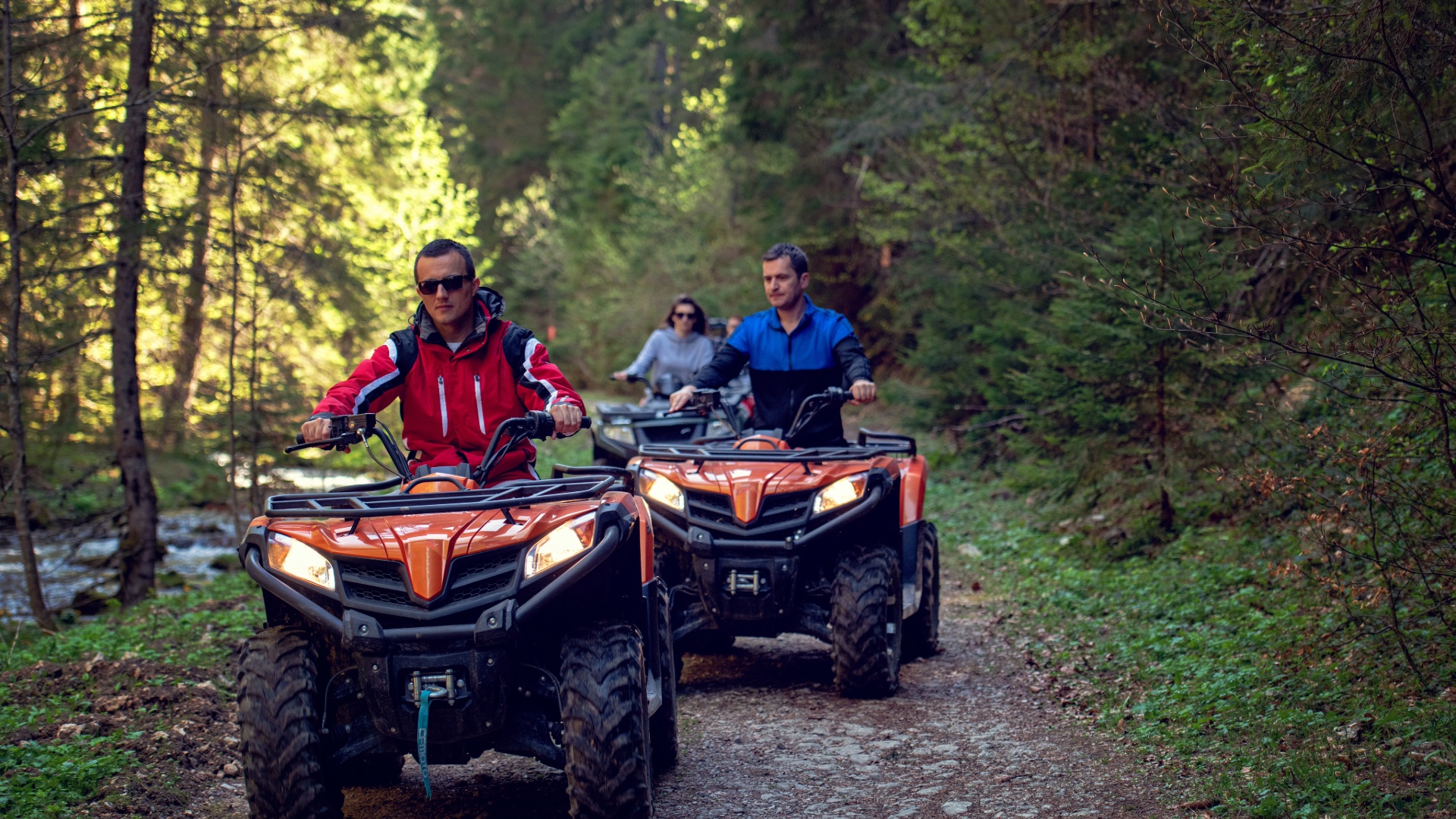 Group of ATV riders on a wooded trail