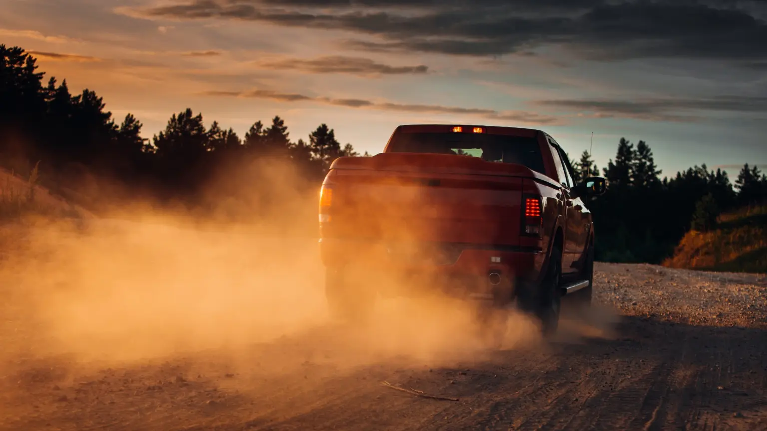 Pickup truck driving along a dusty road