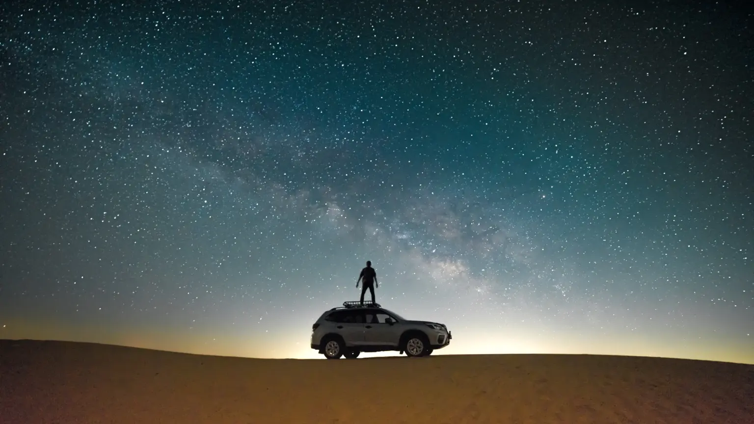 Car beneath a star-filled night sky