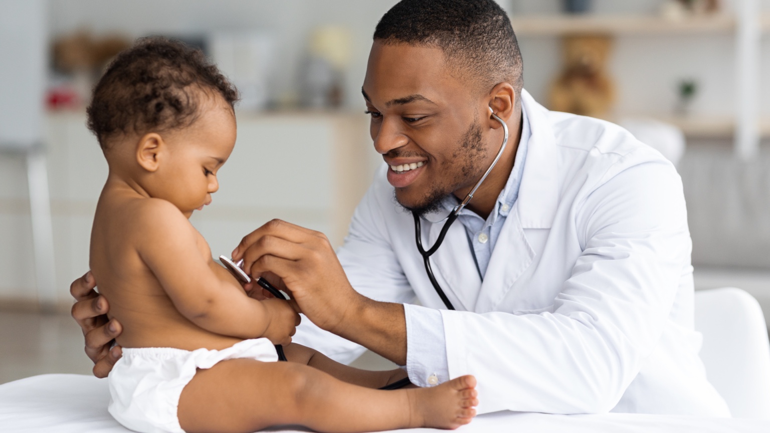 Pediatrician listening to a baby's heartbeat during a medical visit