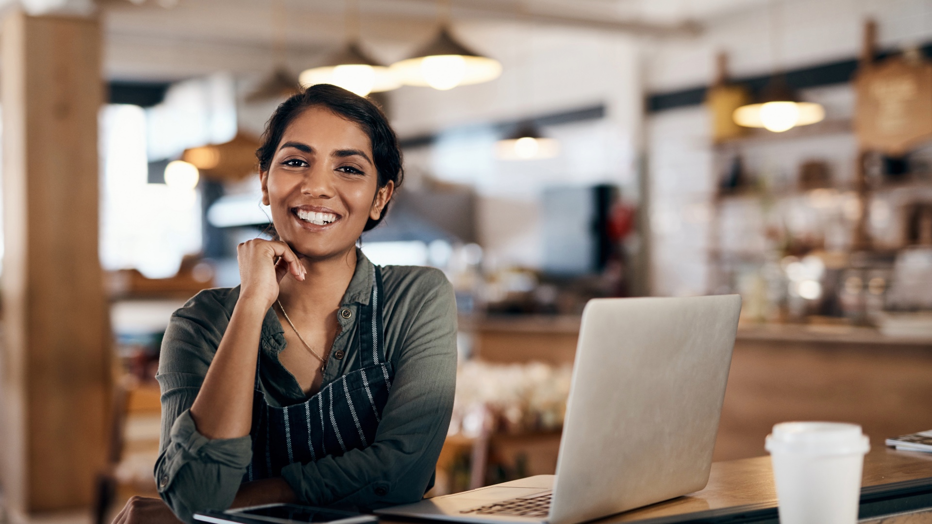 Small business owner working at a laptop in her shop