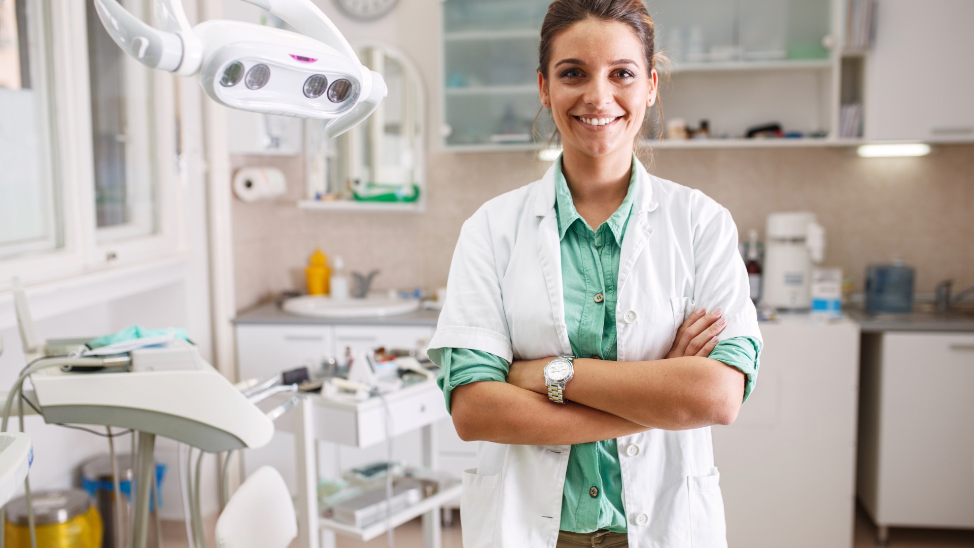 Dental hygienist in a white coat smiling in a dental clinic