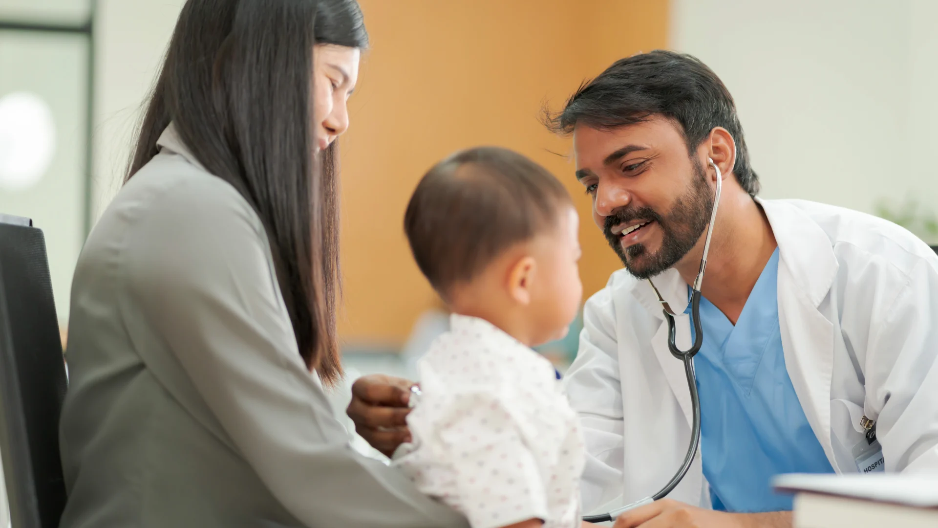 Pediatrician examining a baby with a parent beside them