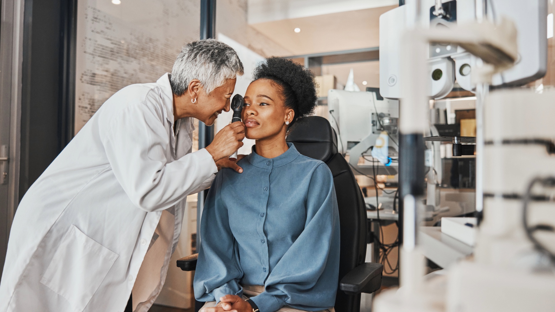 Optometrist examining a patient's eyes during an eye exam