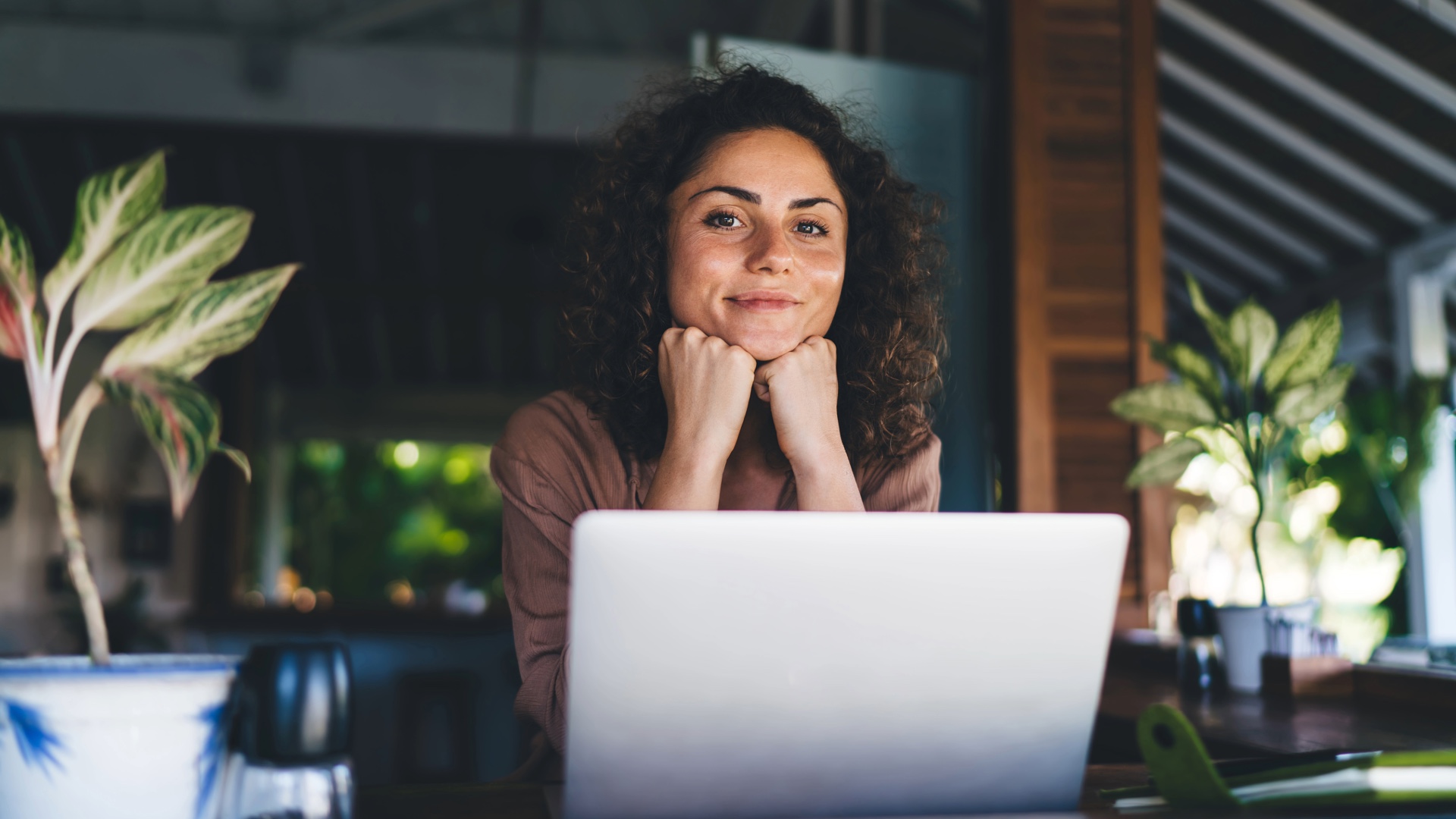 Woman smiling as she uses her laptop at home