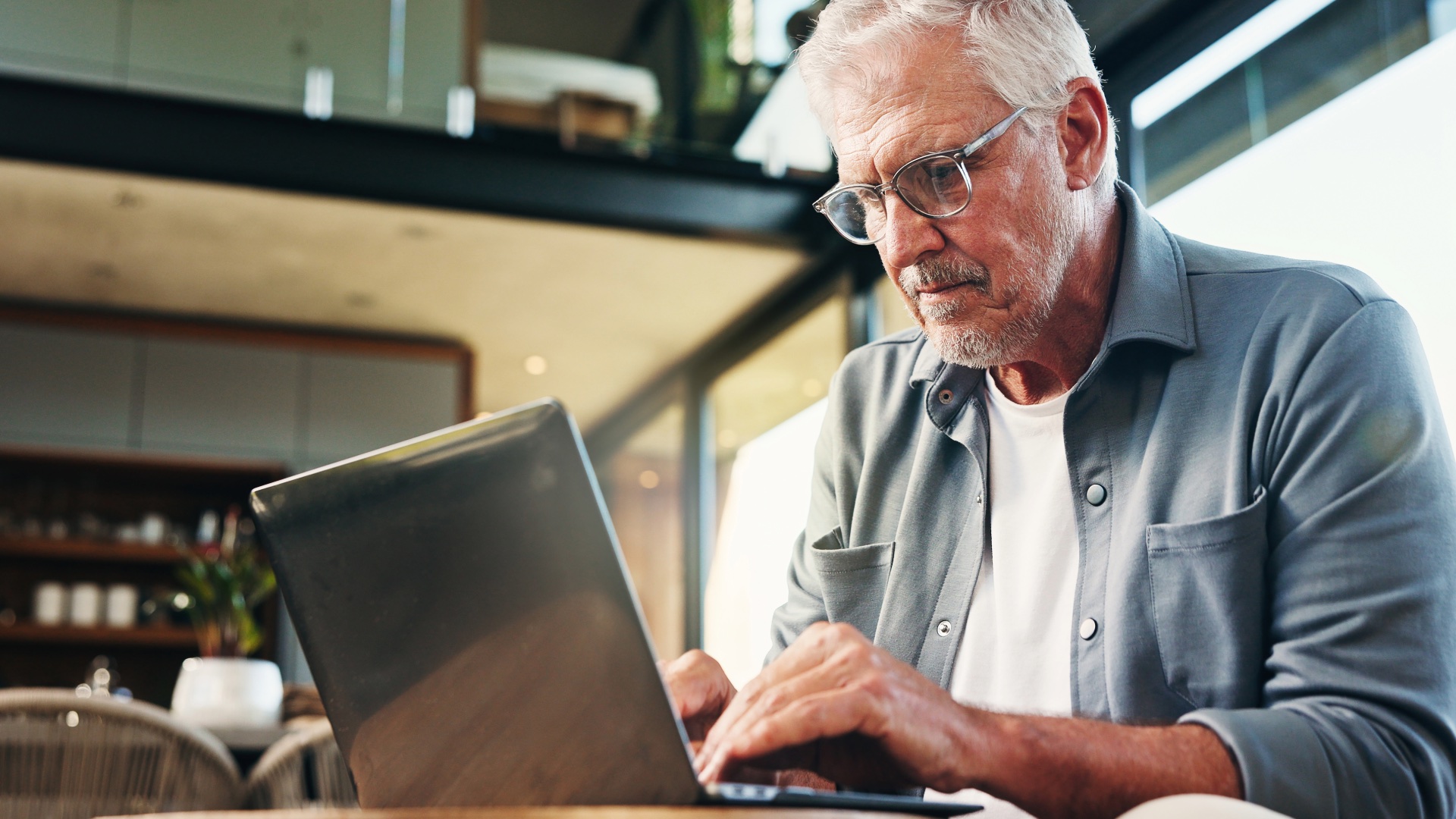 Retired man reviewing information on a laptop