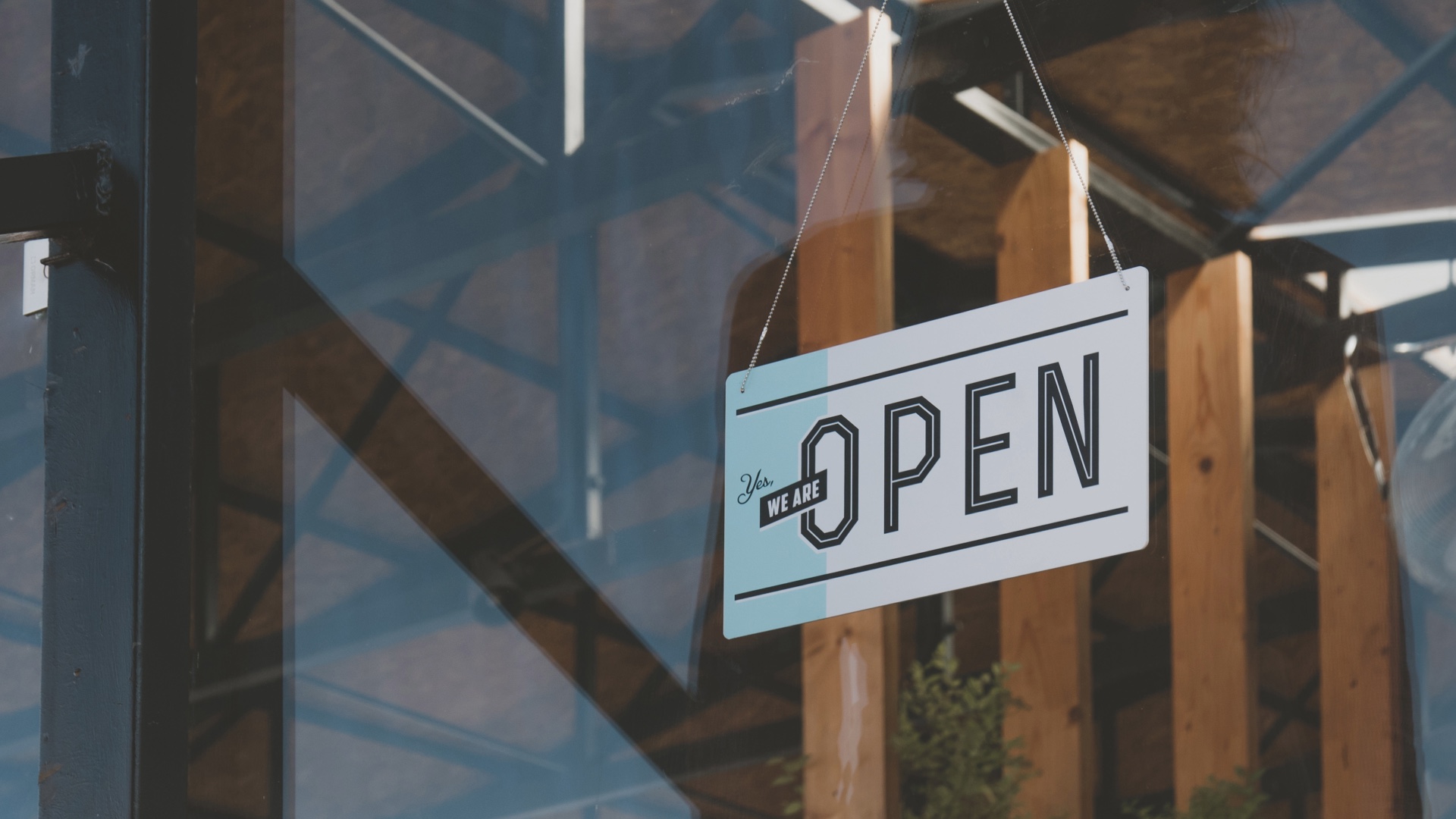We are open sign hanging in a storefront window