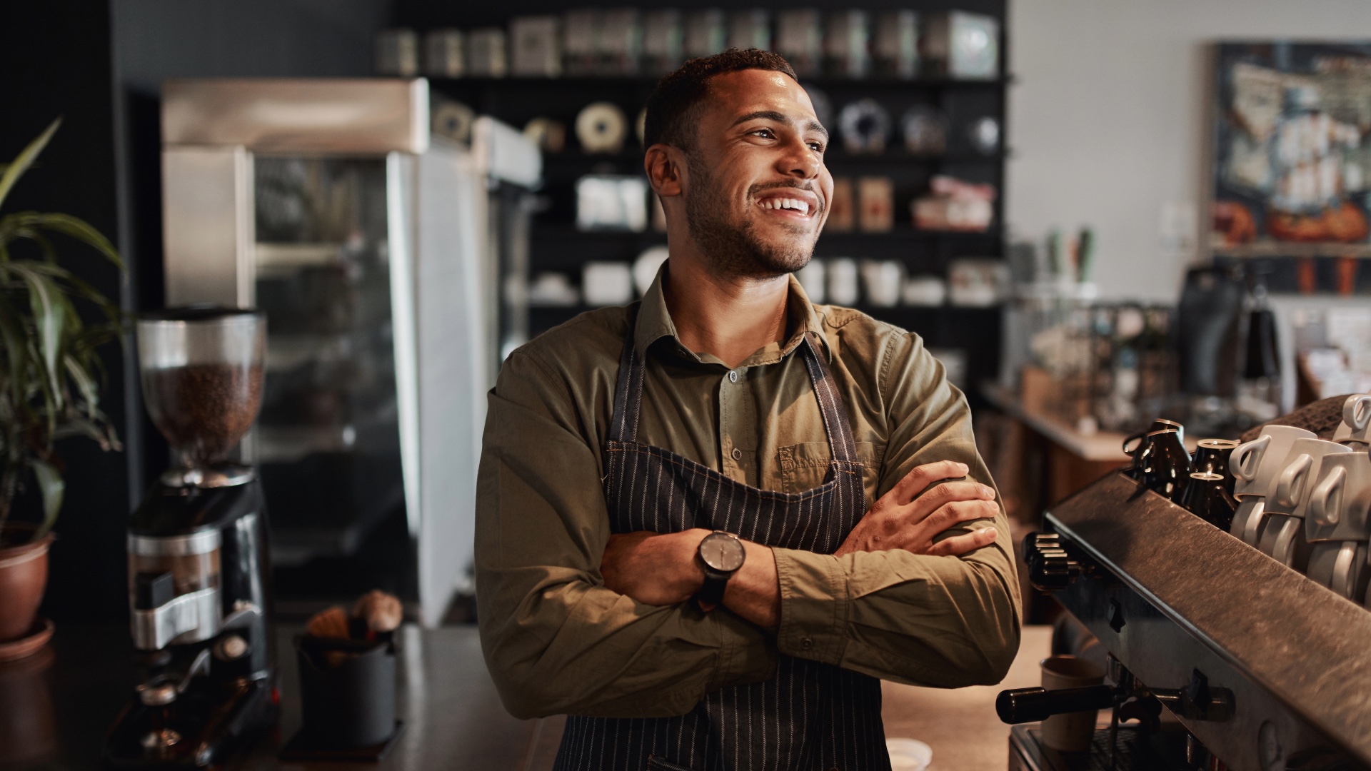 Cafe owner standing beside an espresso machine
