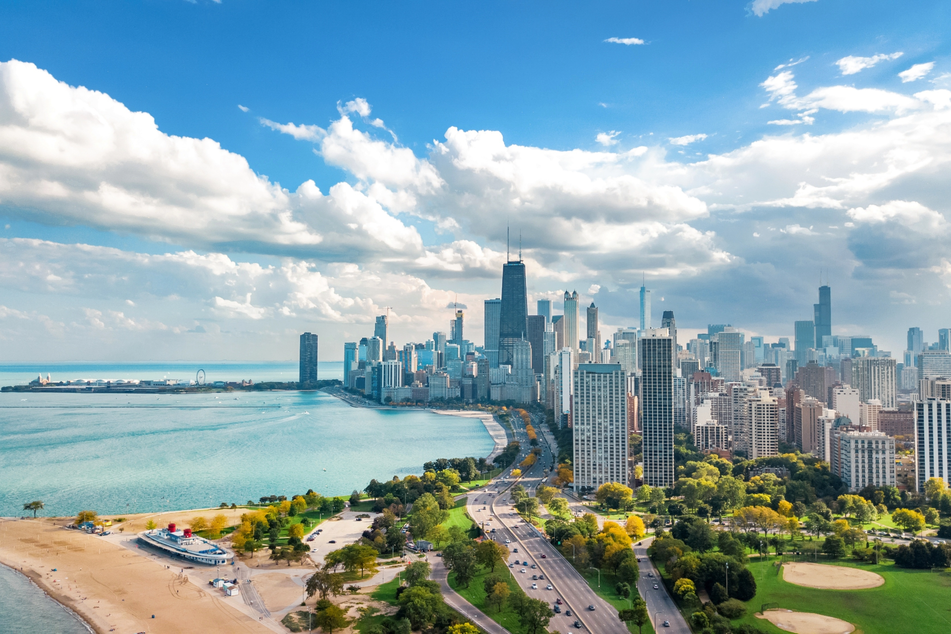 Chicago skyline along Lake Michigan beneath a bright blue sky