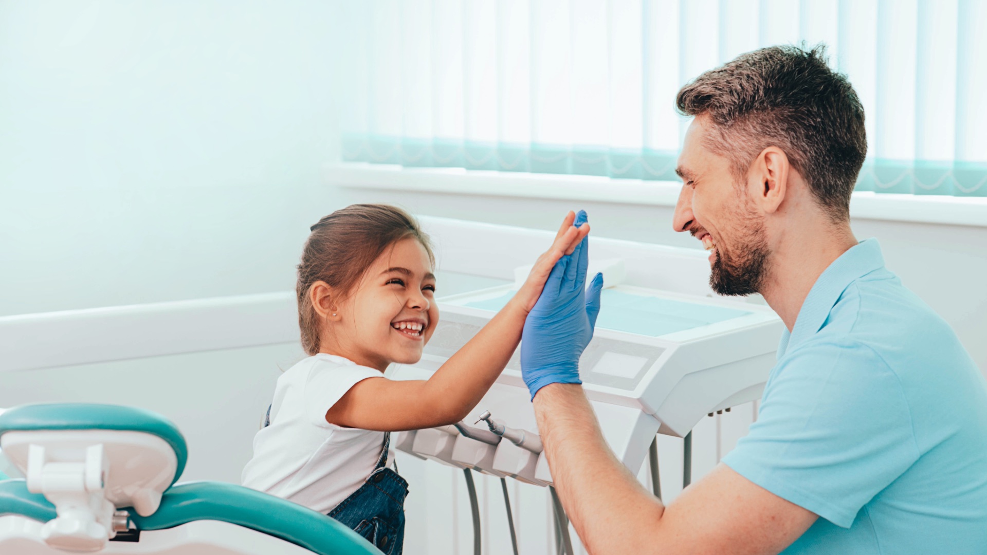 Child high-fiving her dentist after a visit