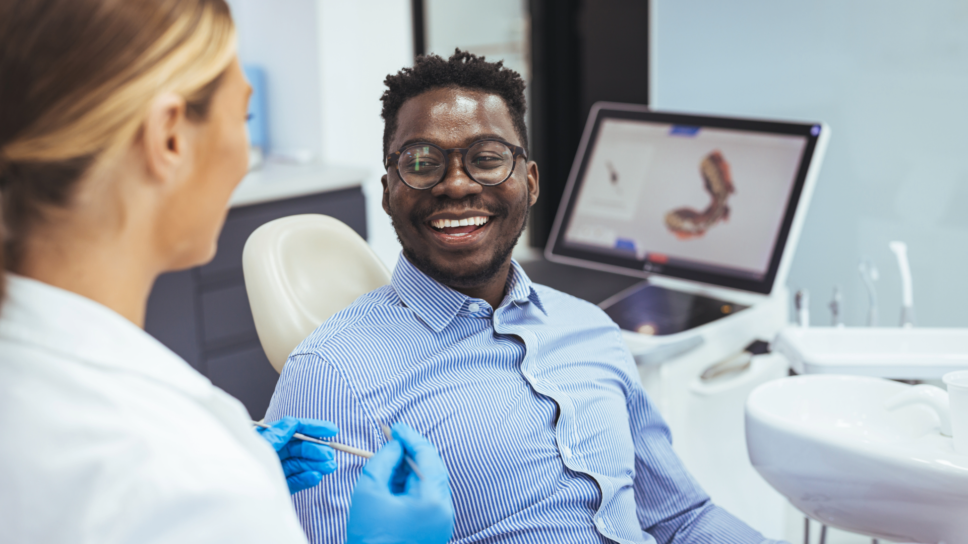 Smiling patient talking with his dentist during a dental visit
