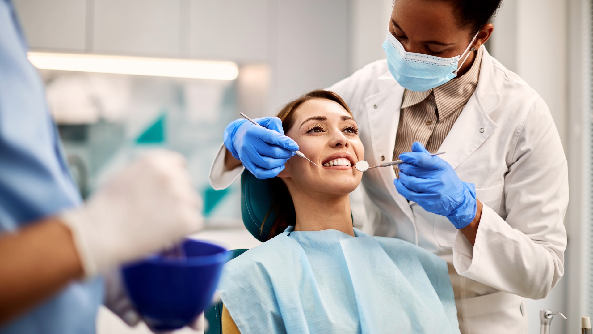 Dental professionals examining a smiling patient