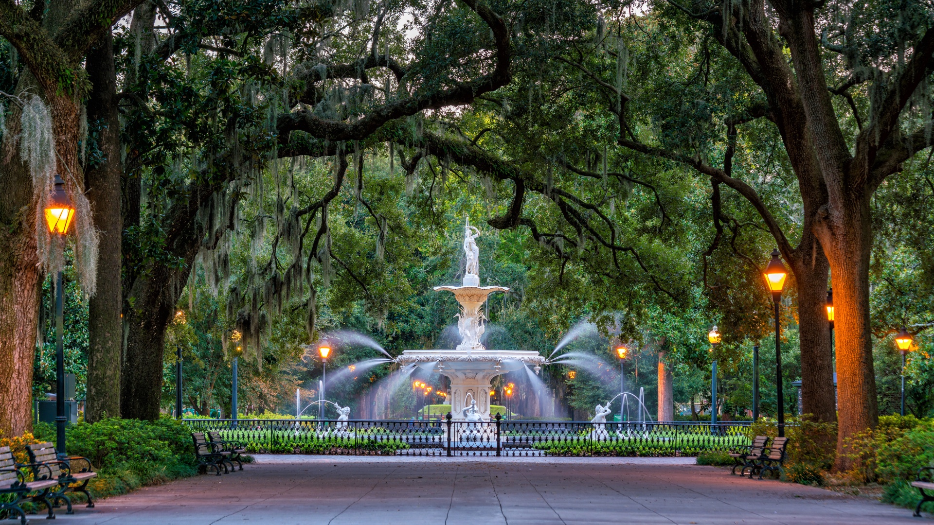 Forsyth Park fountain framed by oak trees, Spanish moss, and glowing lamps in Savannah, Georgia