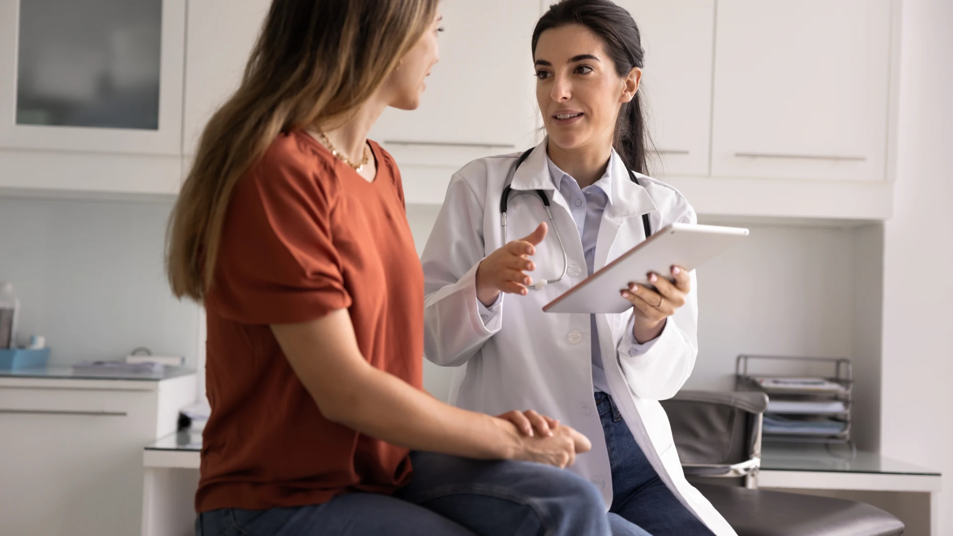 Doctor discussing care with a woman while holding a tablet