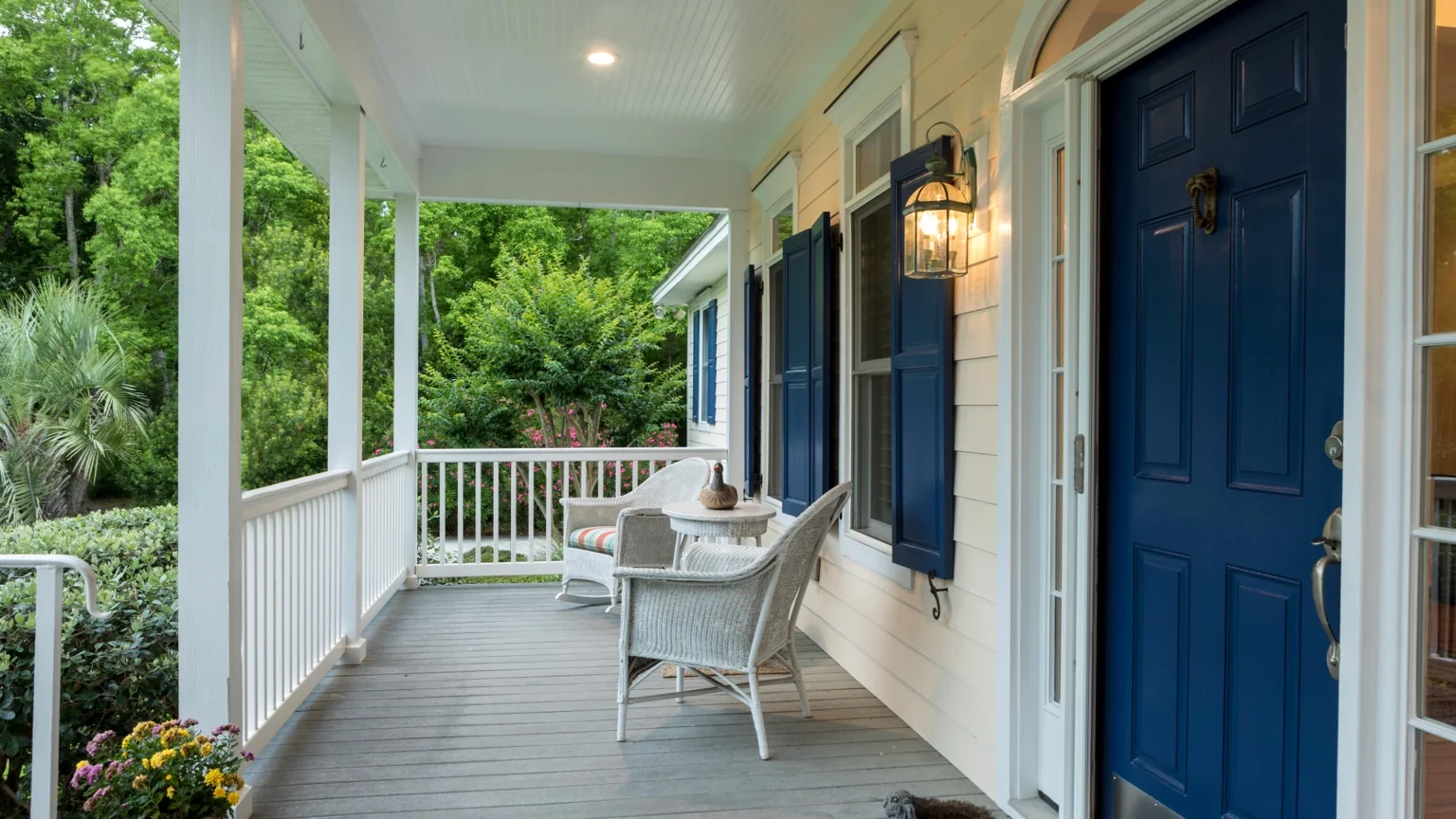 Covered front porch with navy doors and outdoor seating