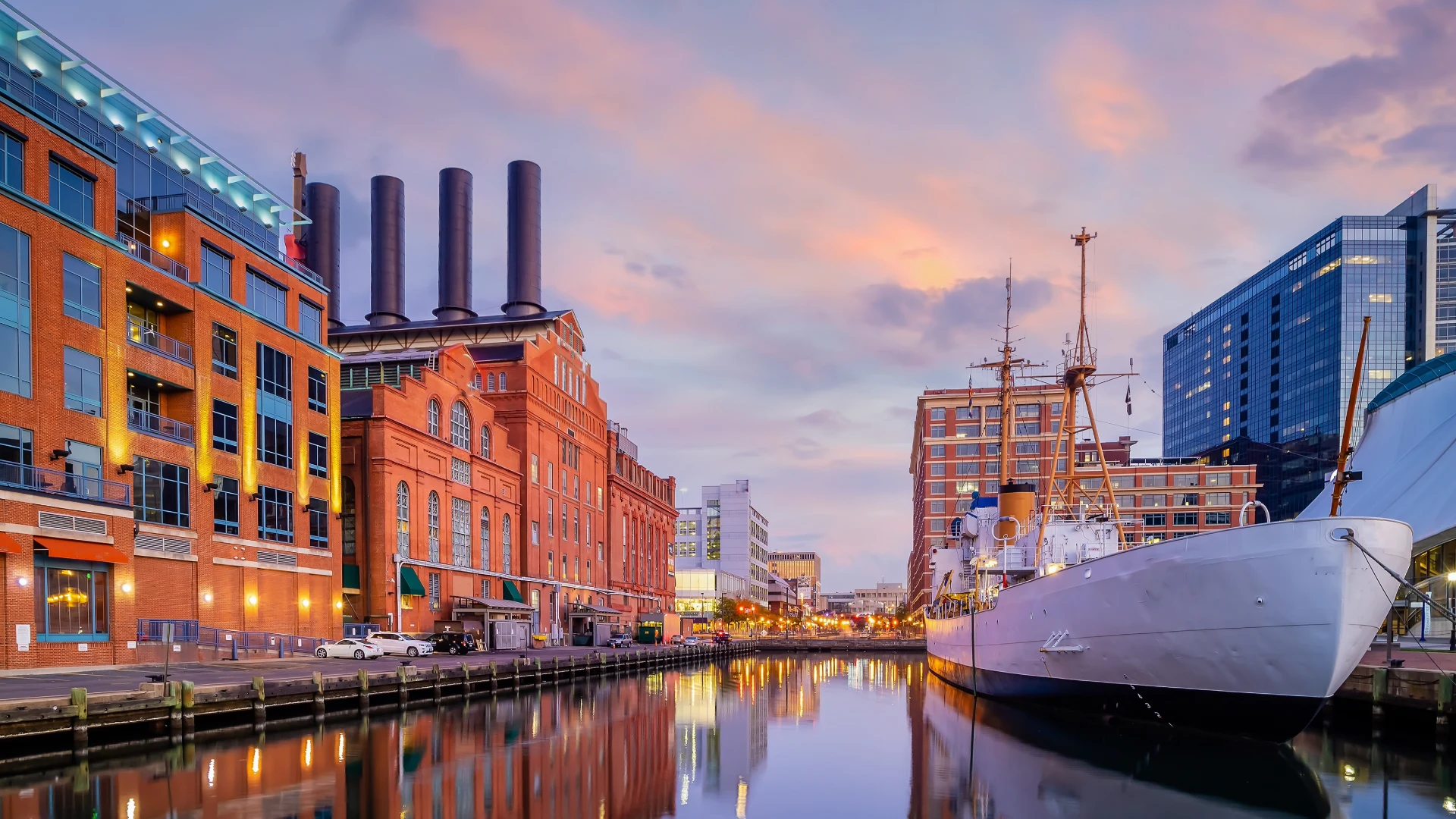 Historic ship and waterfront buildings at Baltimore Inner Harbor at sunset