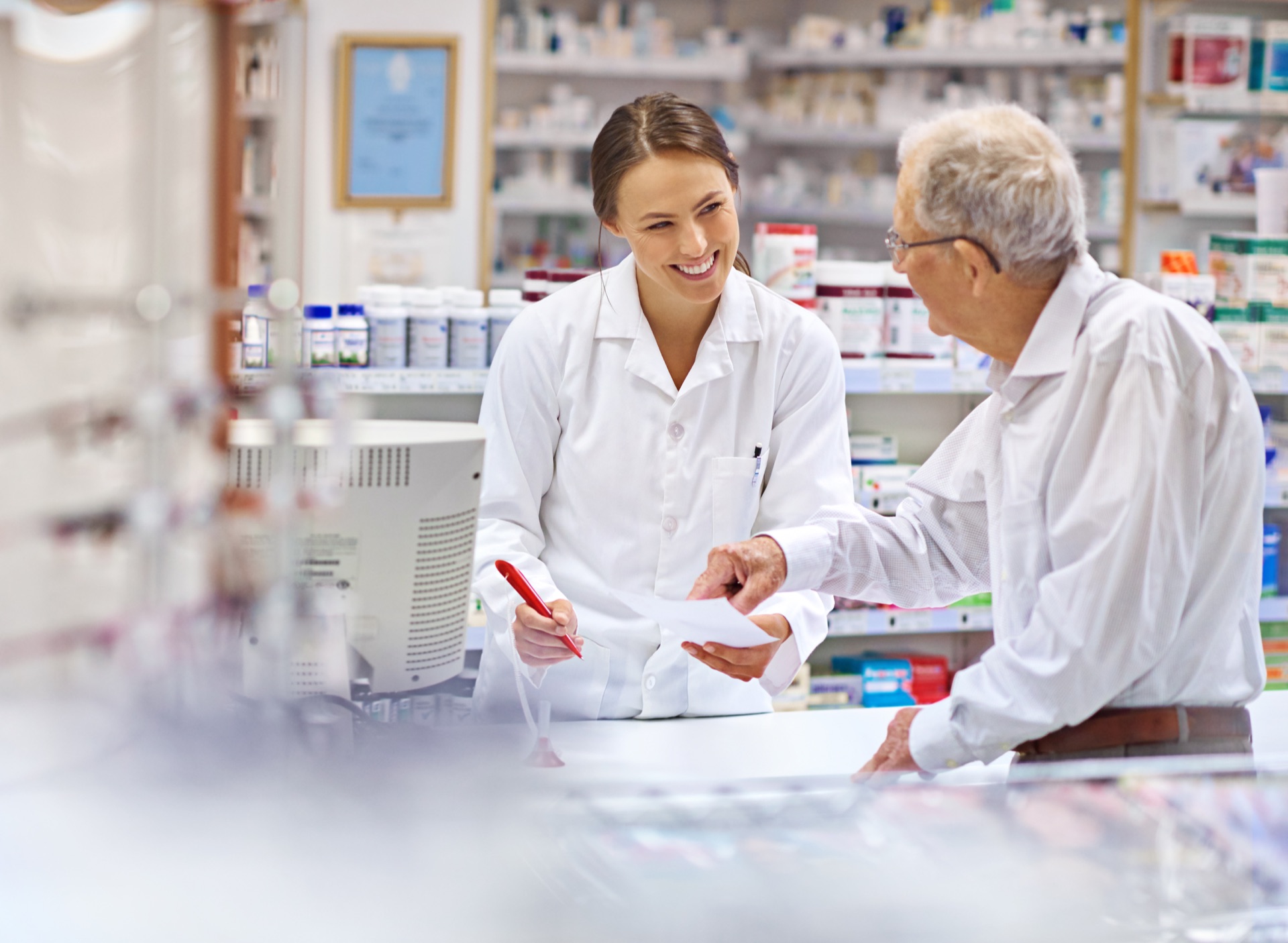 Pharmacist helping an older customer with a prescription