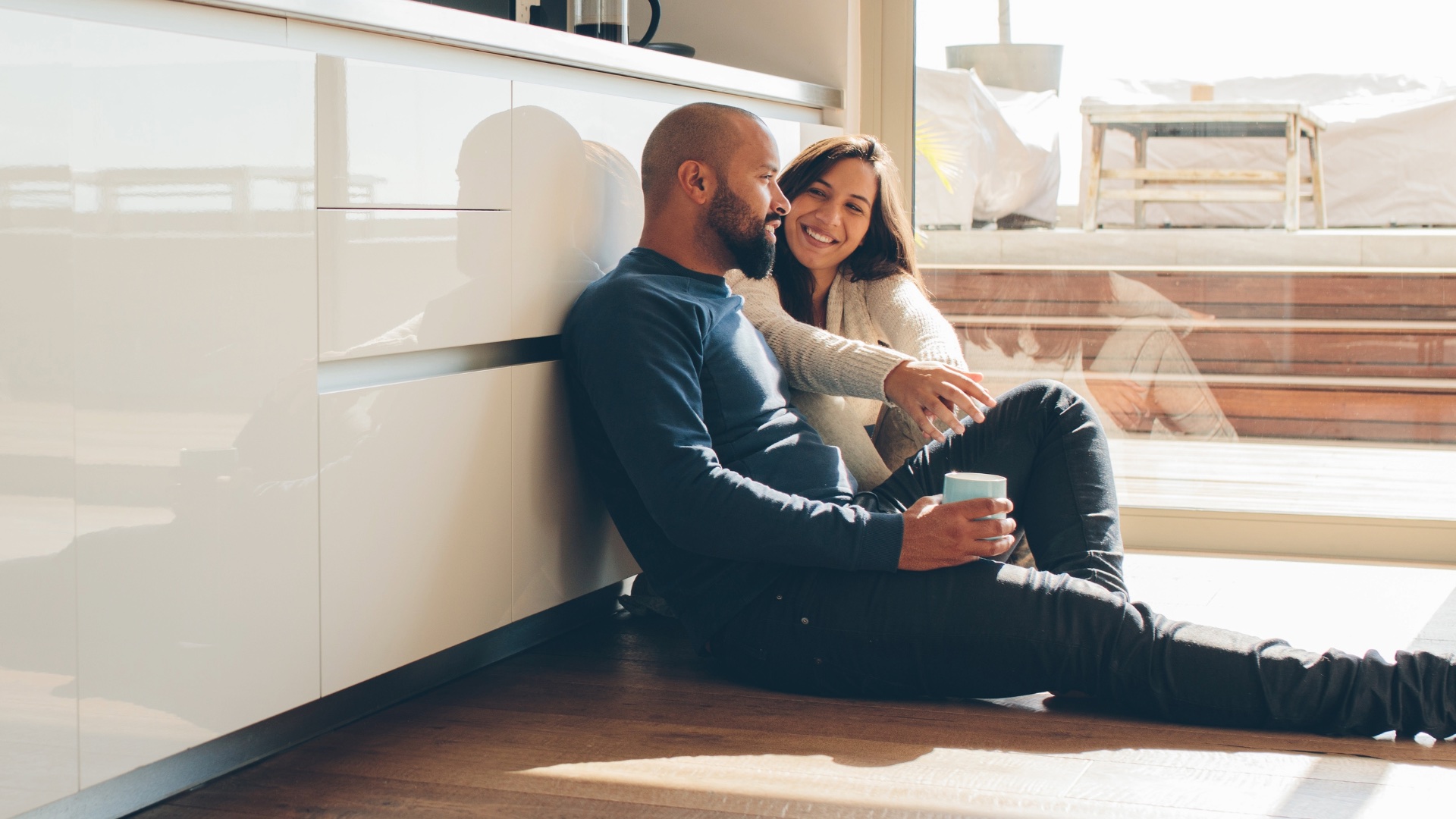 Couple relaxing together with coffee in a bright kitchen