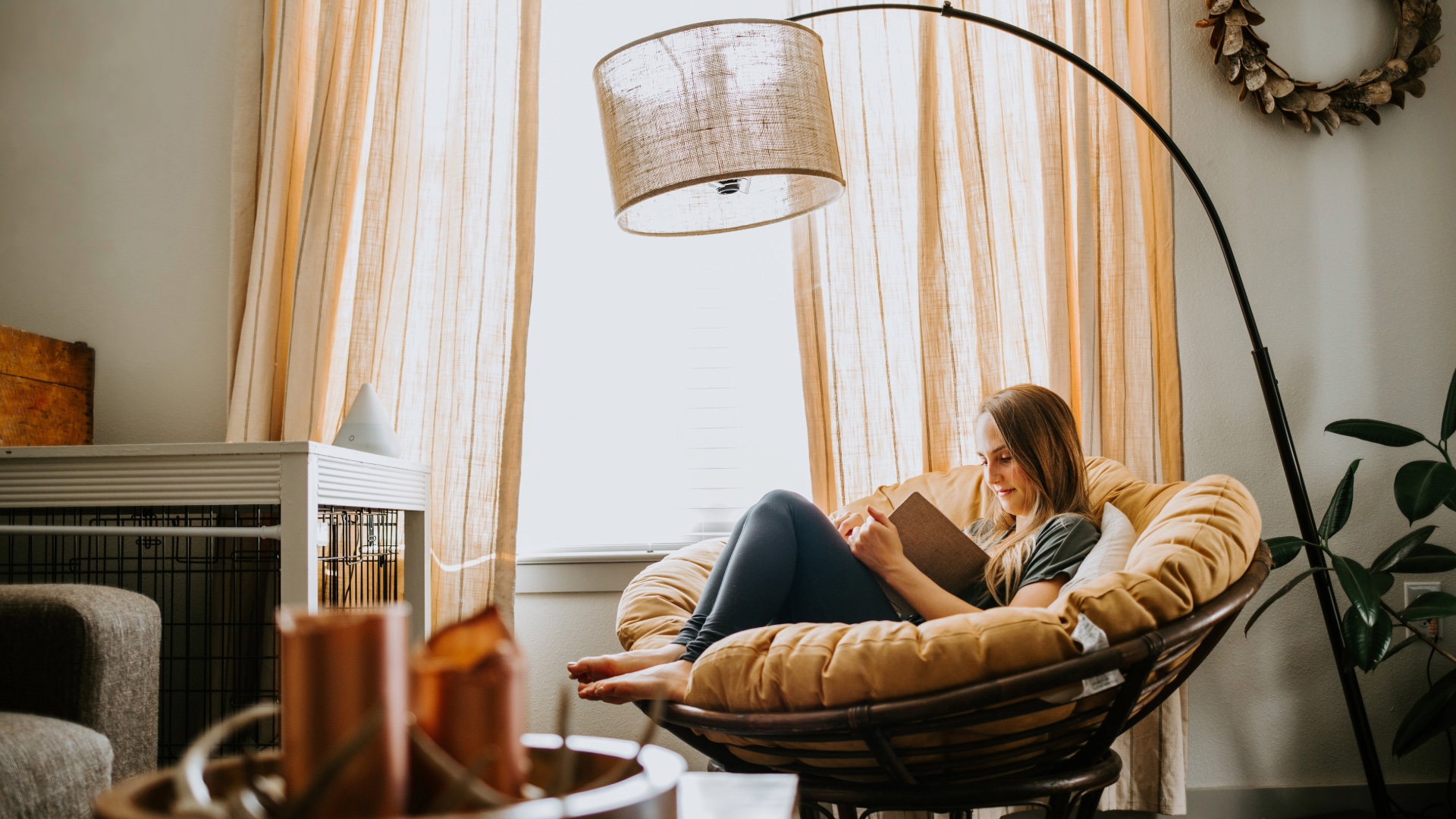 Woman reading in a cozy chair beside a sunlit window