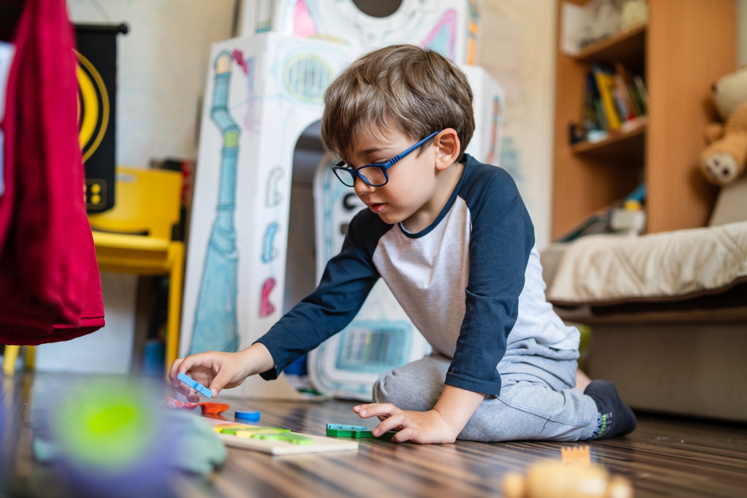 Child wearing eyeglasses while playing at home