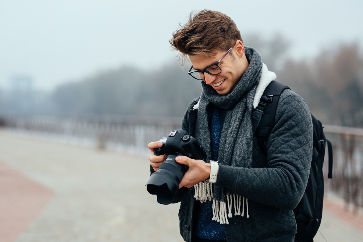 Photographer wearing eyeglasses and reviewing his camera